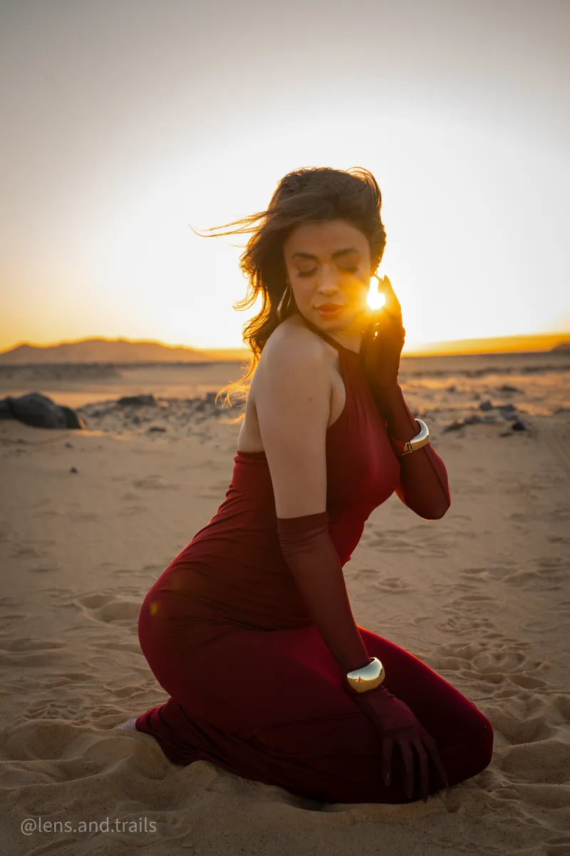 Kniende Pose im roten Kleid mit Sonnenblende