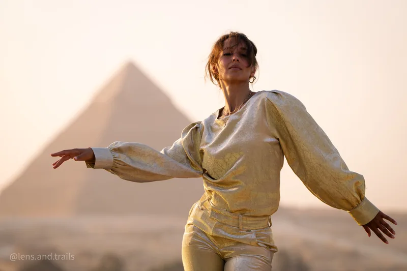 Taenzerin in Gold vor den Pyramiden im warmen Licht