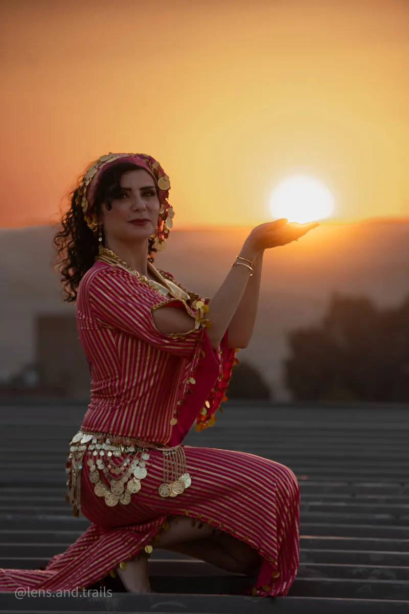 Traditionelle Taenzerin haelt die Sonne an den Pyramiden