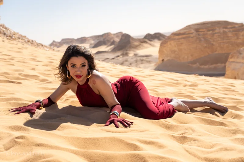 Frau im roten Kleid auf dem Sand der Weissen Wueste